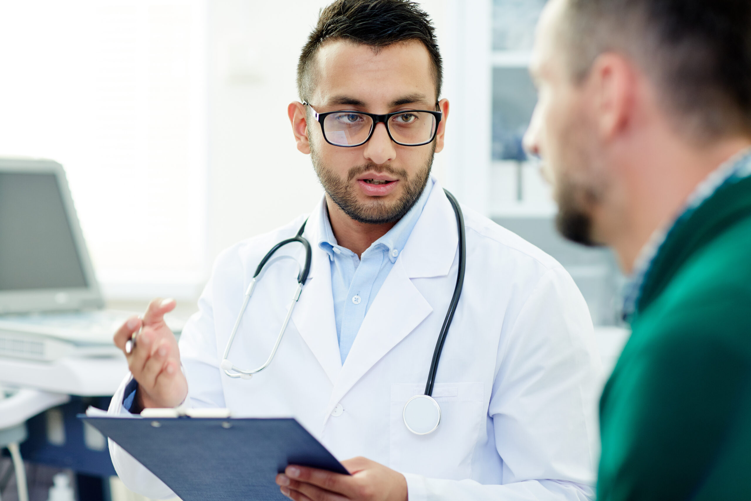 Un médecin parcourt le dossier médical d'un patient venu de l'étranger, lors d'une consultation dans le couloir de la clinique